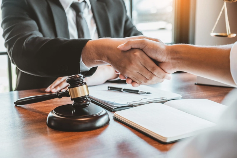 A lawyer and client shake hands in an office, symbolizing a partnership in criminal defense in Myrtle Beach.