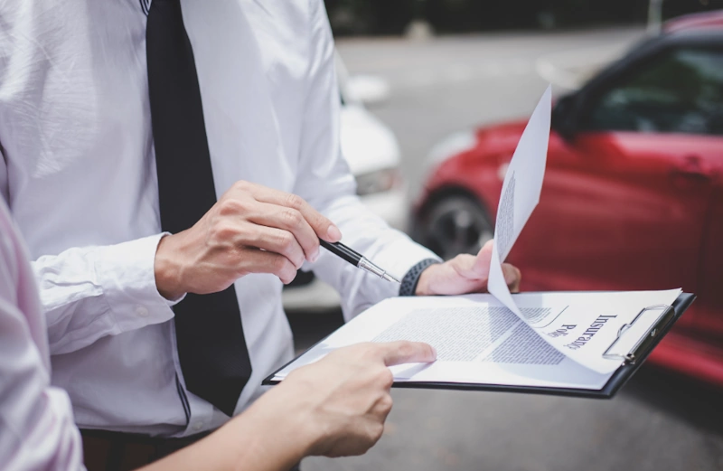 Two individuals reviewing insurance documents following a car accident in Myrtle Beach.