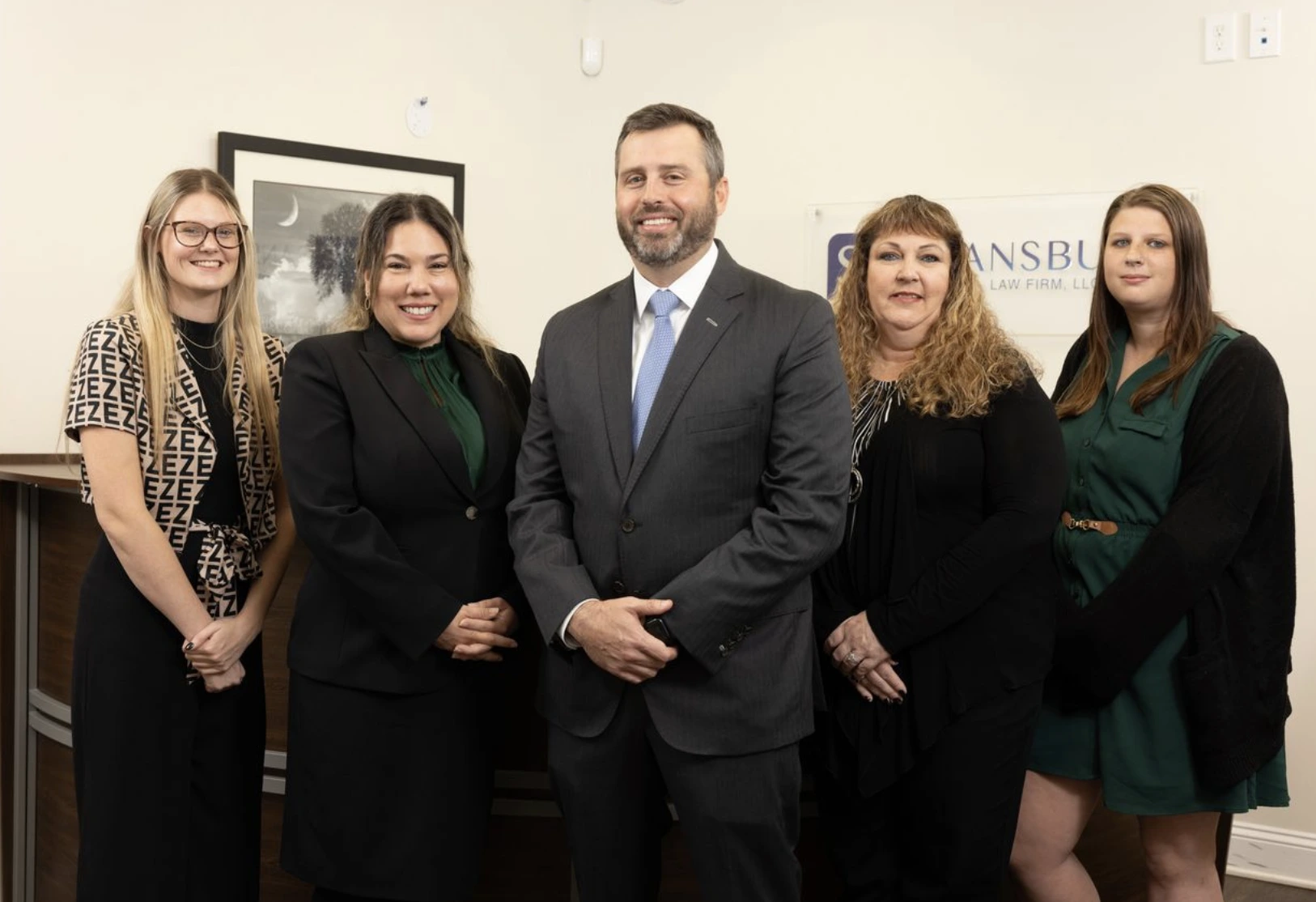 A group of people standing in an office with Marion Car Accident Lawyer in the center.
